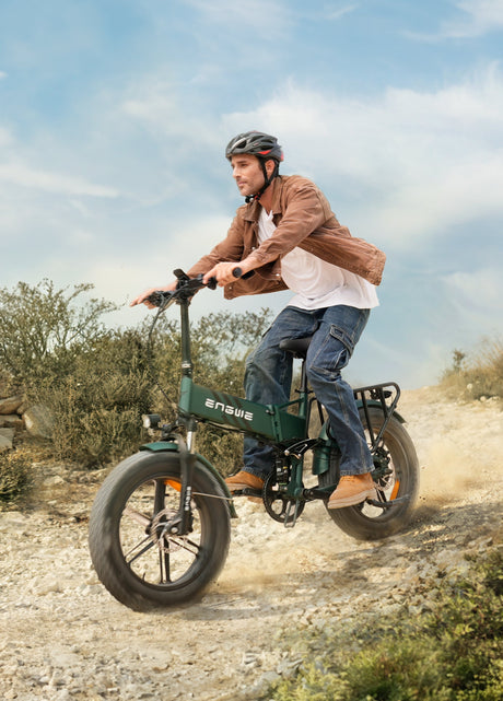 un uomo che indossa un casco in sella a fat bike elettrica mountain green engwe engine pro 2.0 e sulla sabbia
